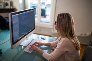 kobieta-pracujaca-siedzaca-przed-monitorem-komputerem